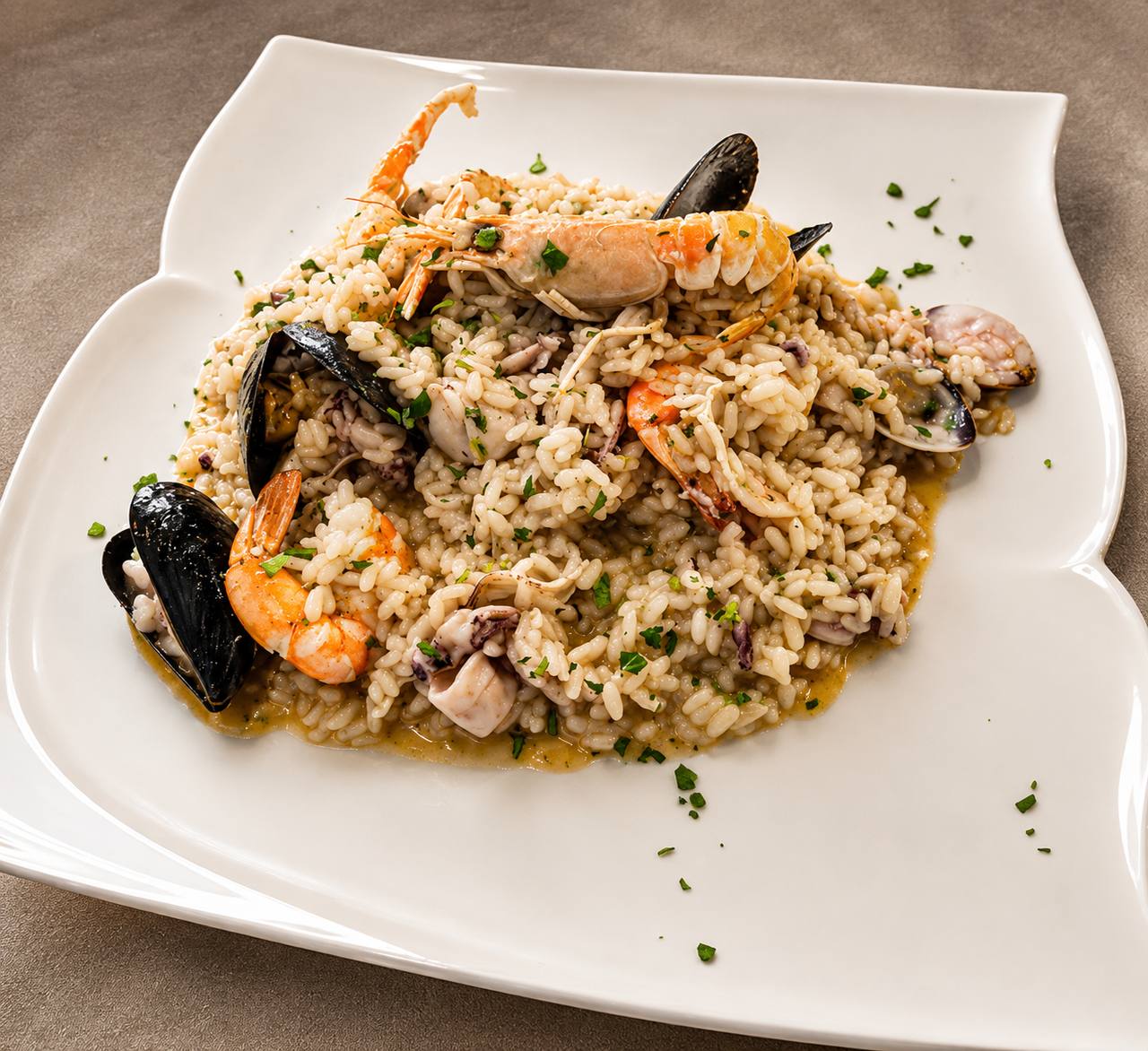 Risotto misto mare con gamberi, cozze e calamari servito nel piatto