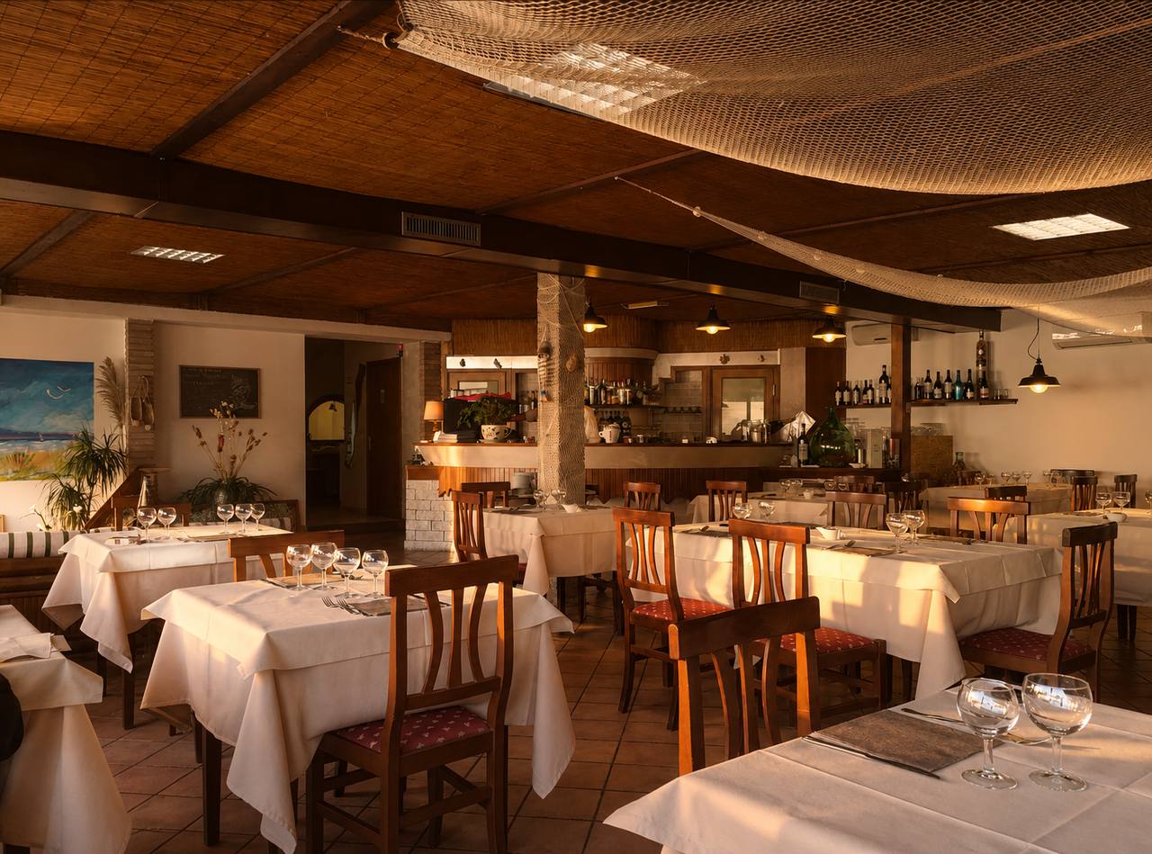 Sala del ristorante Il Peschereccio con tavoli apparecchiati sotto il soffitto in bambù