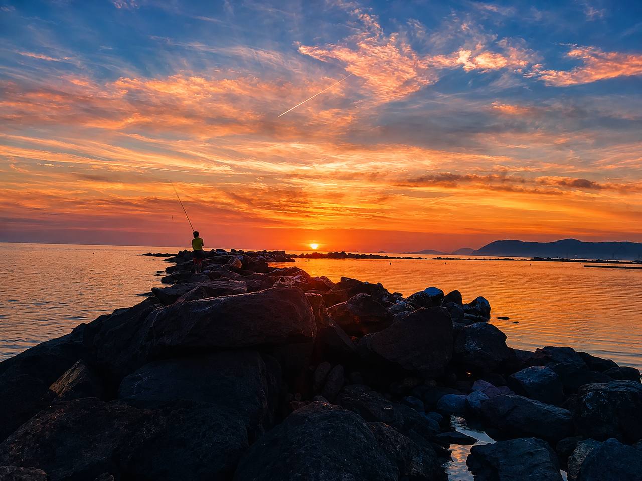 Tramonto sul mare di Marina di Massa con la scogliera in primo piano